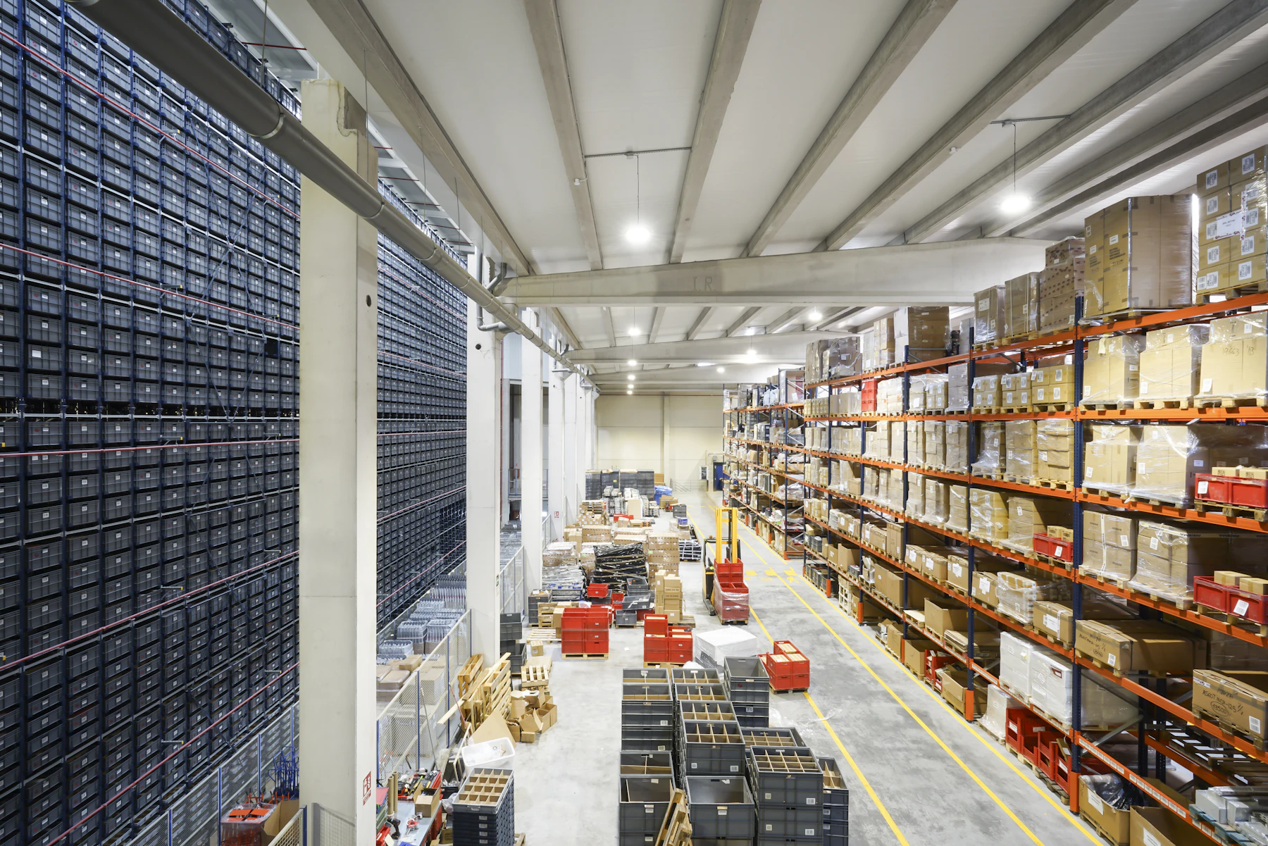 Wide view across an orderly warehouse with palletized goods on storage racks